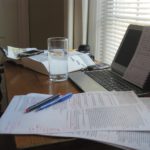 still life photo of writer's desk strewn with author tools